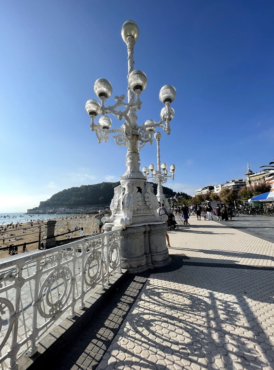 Ornate white lamppost on La Concha promenade, San Sebastián